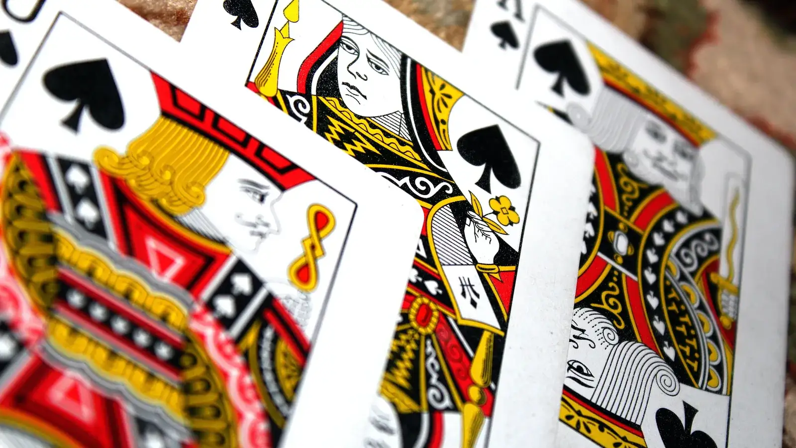 Fanned jack, queen and king of spades playing cards close up