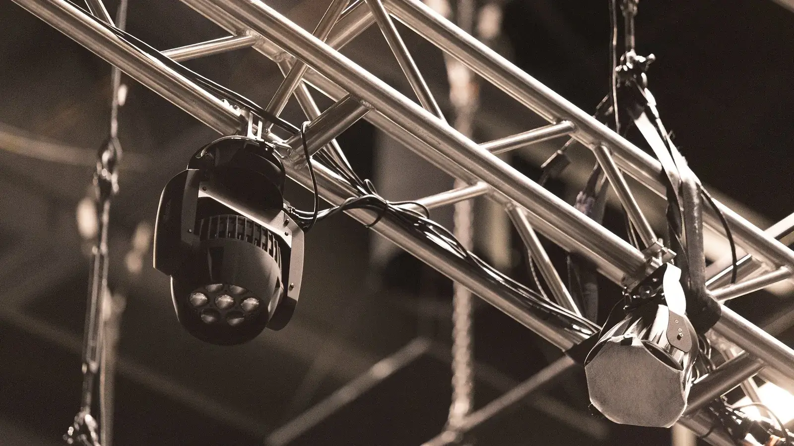 Stage lighting rig on a steel truss against a dark background